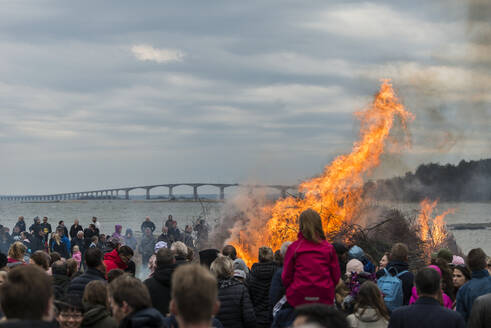 Menschen beobachten großes Lagerfeuer am Strand - JOHF03795