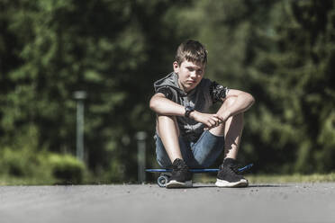 Junge auf Skateboard sitzend - JOHF03846