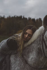 Young woman lying on horse - JOHF03962