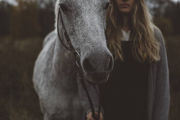 Young woman with horse in field - JOHF03965