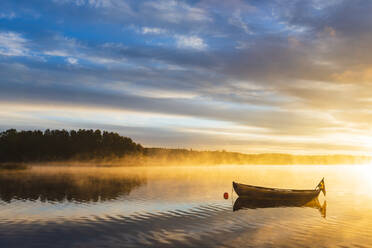 Boat in lake at sunrise - JOHF04180