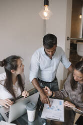 Colleagues working together at table in office - ALBF01178