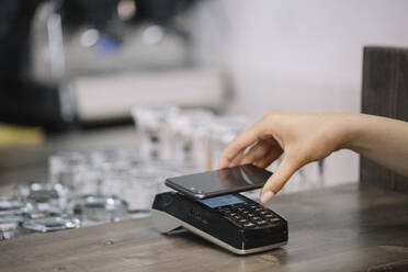 Kunde zahlt bargeldlos mit Smartphone in einem Cafe - ALBF01196