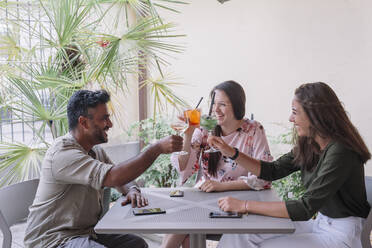 Happy friends sitting at table clinking glasses - ALBF01198