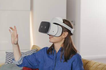 Young woman using VR glasses at home - MFF04870