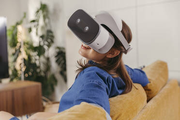 Young woman using VR glasses at home - MFF04874