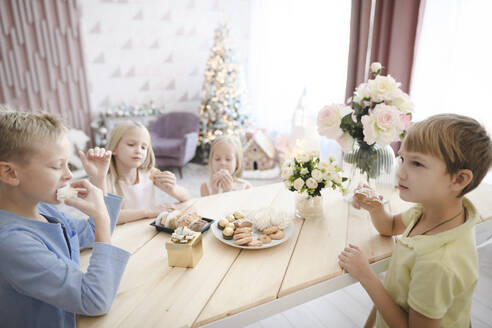 Vier Kinder essen Kekse zu Hause - EYAF00569
