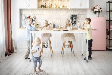 Fünf Kinder essen Kekse in der Küche - EYAF00572
