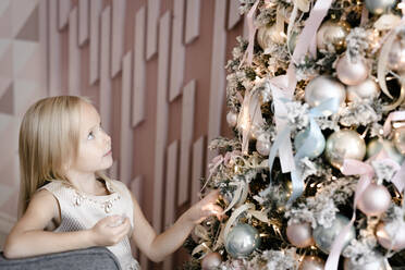 Blondes kleines Mädchen beobachtet Weihnachtsbaum - EYAF00581