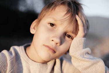 Portrait of pensive boy with head in his hand - EYAF00603