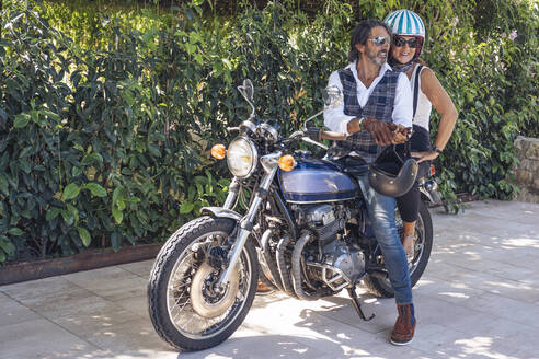 Glückliches reifes Paar auf einem alten Motorrad - DLTSF00249