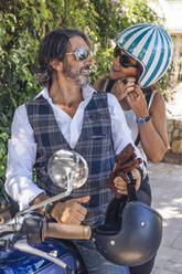 Portait of happy mature couple on a vintage motorbike - DLTSF00250