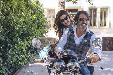 Portait of happy mature couple on a vintage motorbike - DLTSF00254