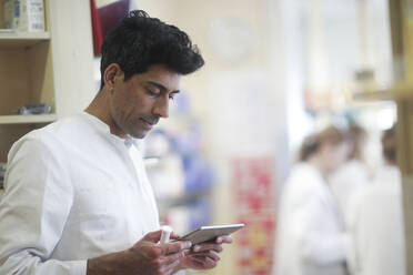 Pharmacist in a pharmacy with a tablet - CAVF65136