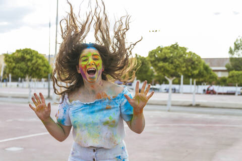 Teenager-Mädchen springt und schreit vor Freude, spielt mit farbigem Puder und, lizenzfreies Stockfoto