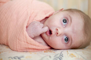 Neugeborenes Baby Mädchen mit niedlichen Ausdruck Blick nach oben in rosa gewickelt - CAVF65212