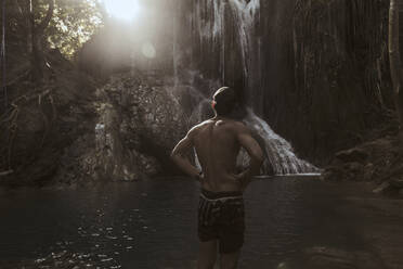 Mann steht in der Nähe eines Wasserfalls - CAVF65282