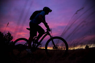 Eine Mountainbikerin fährt bei Sonnenuntergang in der Nähe von Missoula, Montana - CAVF65289