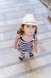 Porträt eines kleinen Mädchens, das im Sommer einen Lutscher lutscht - GEMF03216