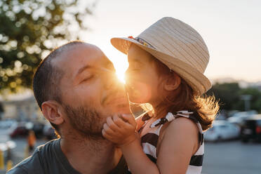 Kleines Mädchen küsst ihren Vater bei Sonnenuntergang - GEMF03225