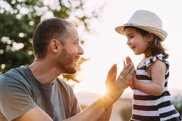 Vater und kleine Tochter spielen zusammen bei Sonnenuntergang - GEMF03229