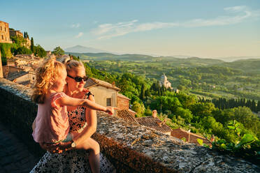 Mother and daughter admiring Tuscany landscape - CAVF65355