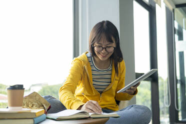 Young collage student using computer and mobile device studying - CAVF65385