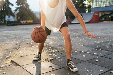 Männer mit kurvigem Haar spielen Basketball im Freien, Nahaufnahme - CAVF65414