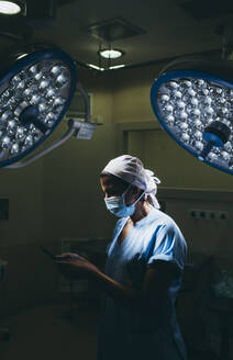 Krankenschwester benutzt ein Mobiltelefon im Operationssaal - DAMF00192