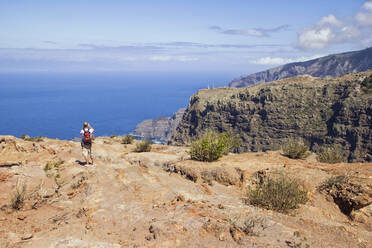 Hiker at the coast enjoying the view, Agulo, La Gomera, Canary Islands, Spain - MAMF00882