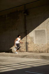 African-American man running on sidewalk - CAVF65494