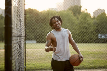 Afroamerikanischer Mann spielt Basketball im Freien - CAVF65511