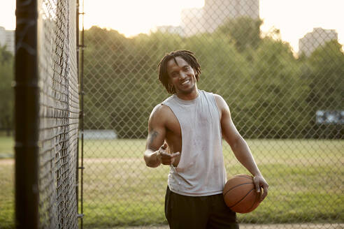 Afroamerikanischer Mann spielt Basketball im Freien - CAVF65511