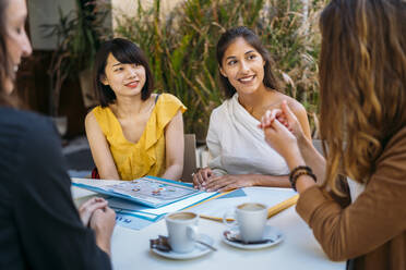Multikulturelle Studentinnen treffen sich in einem Café und organisieren ihren Stundenplan - MPPF00111