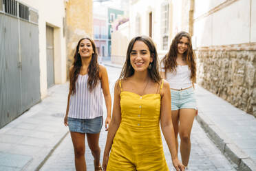 Three happy female friends walking in an alley - MPPF00155