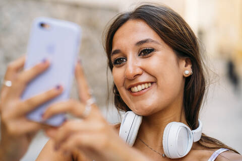 Schöne junge Frau mit Kopfhörern und Mobiltelefon, lizenzfreies Stockfoto