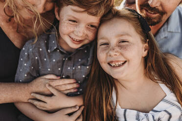 Close up detail of family of four playing during sunset at beach - CAVF65553