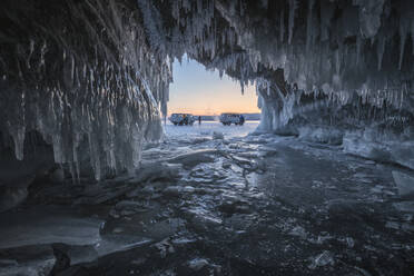 Zwei Vans warten vor einer Höhle im Baikalsee. - CAVF65644