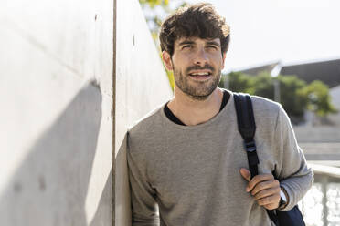 Mann mit Rucksack bei einer Pause in der Stadt - GIOF07226