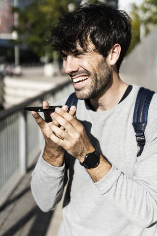 Glücklicher Mann mit Smartphone in der Stadt, lizenzfreies Stockfoto