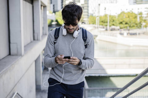 Mann mit Smartphone in der Stadt unterwegs, lizenzfreies Stockfoto