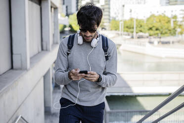 Mann mit Smartphone in der Stadt unterwegs - GIOF07252