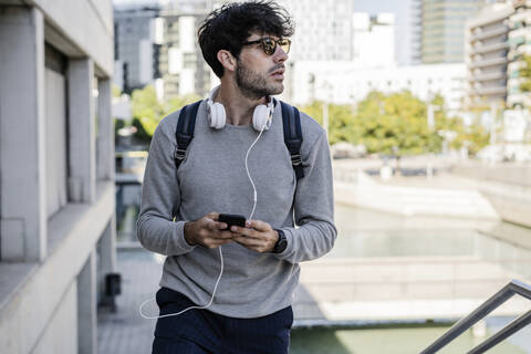 Mann mit Smartphone in der Stadt unterwegs, lizenzfreies Stockfoto