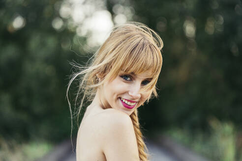 Porträt einer lächelnden blonden jungen Frau in der Natur - MTBF00033