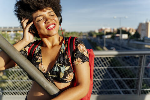 Weibliche Afroamerikanerin mit Kopfhörern hört Musik, lizenzfreies Stockfoto