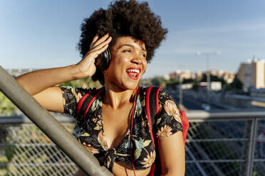 Weibliche Afroamerikanerin mit Kopfhörern hört Musik und schaut zur Seite - ERRF01739