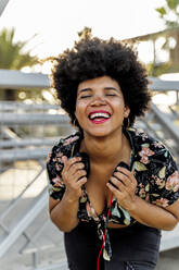 Porträt einer lachenden afro-amerikanischen Frau mit Kopfhörern - ERRF01758