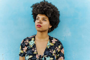 Portrait of Afro-American woman looking sideways, blue wall in the background - ERRF01771
