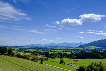 Deutschland, Bayern, Mittelberg, Himmel über ländlichem Dorf mit Bergen im Hintergrund - LBF02751