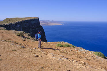 Spanien, Kanarische Inseln, Wanderin bewundert das Meer vom Rand der Küstenklippe - SIEF09169